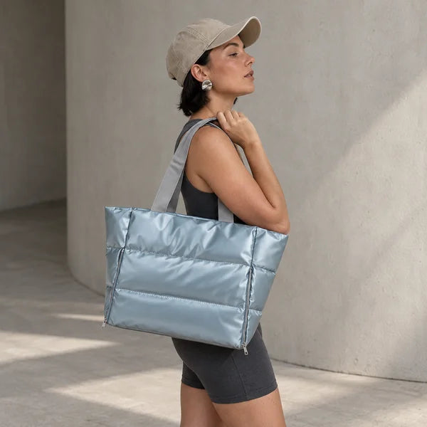 Illustrative image of a woman carrying the Blue Everyday Puffer over her shoulder