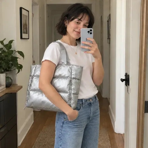 Illustrative AI-generated mirror photo of a woman carrying a silver puffer tote
