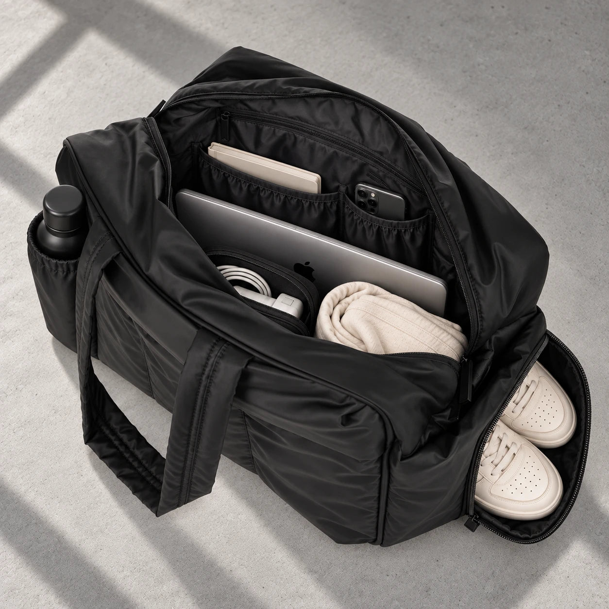 Black All-Day Tote packed with a laptop, notebook, phone, bottle and shoes in a separate compartment